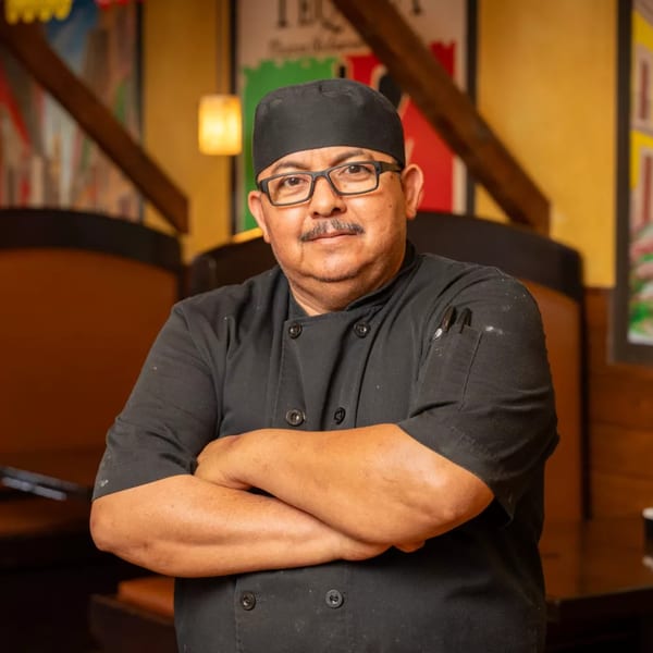 Grand Tequila Mexican Restaurant chef in black uniform and glasses, arms crossed, smiling at the camera.