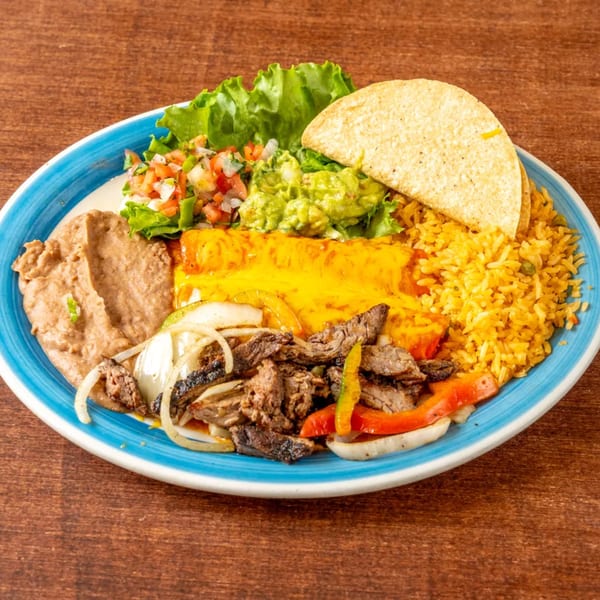 A Grand Tequila Mexican Restaurant combo plate with steak fajitas, enchilada, rice, beans, guacamole, pico de gallo, and a taco.
