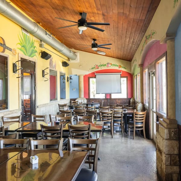 Interior of Grand Tequila Mexican Restaurant with colorful walls, wooden tables, and chairs.